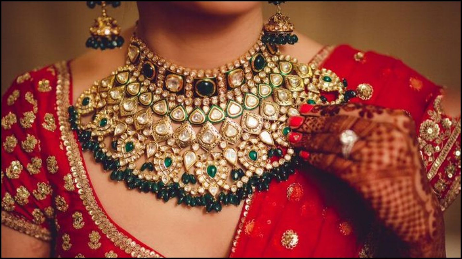 Photo of Bride in red lehenga green jewellery